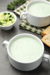 Photo of Tasty cucumber soup served on grey table, closeup