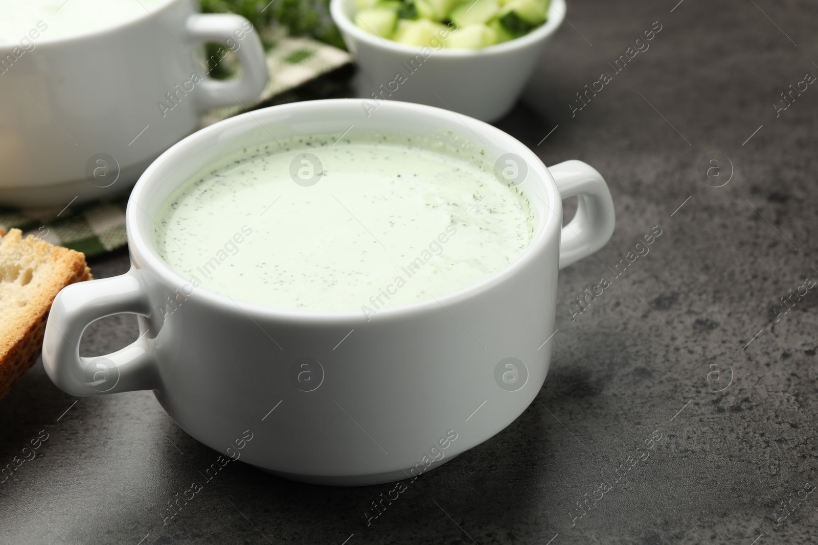 Tasty cucumber soup served on grey table, closeup Photo of Tasty cucumber soup served on grey table, closeup