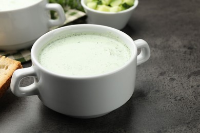 Photo of Tasty cucumber soup served on grey table, closeup