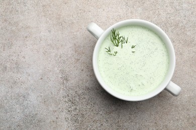 Photo of Tasty cucumber soup with dill on grey table, top view. Space for text