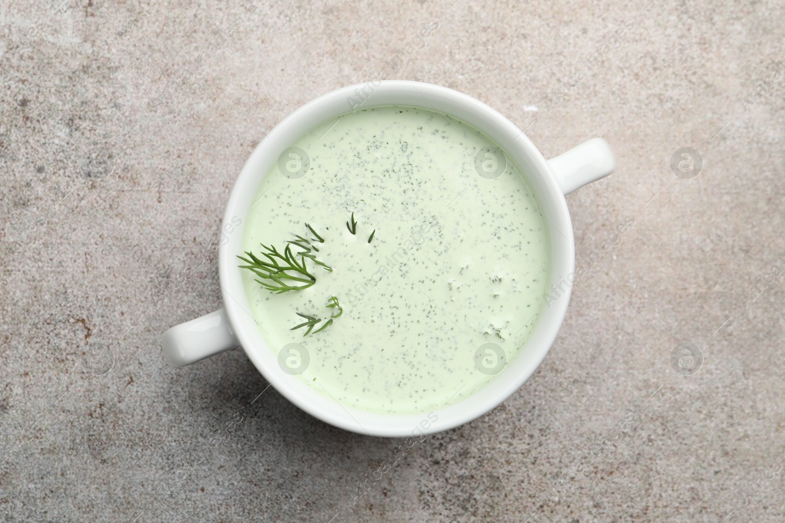 Photo of Tasty cucumber soup with dill on grey table, top view
