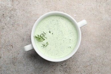 Photo of Tasty cucumber soup with dill on grey table, top view