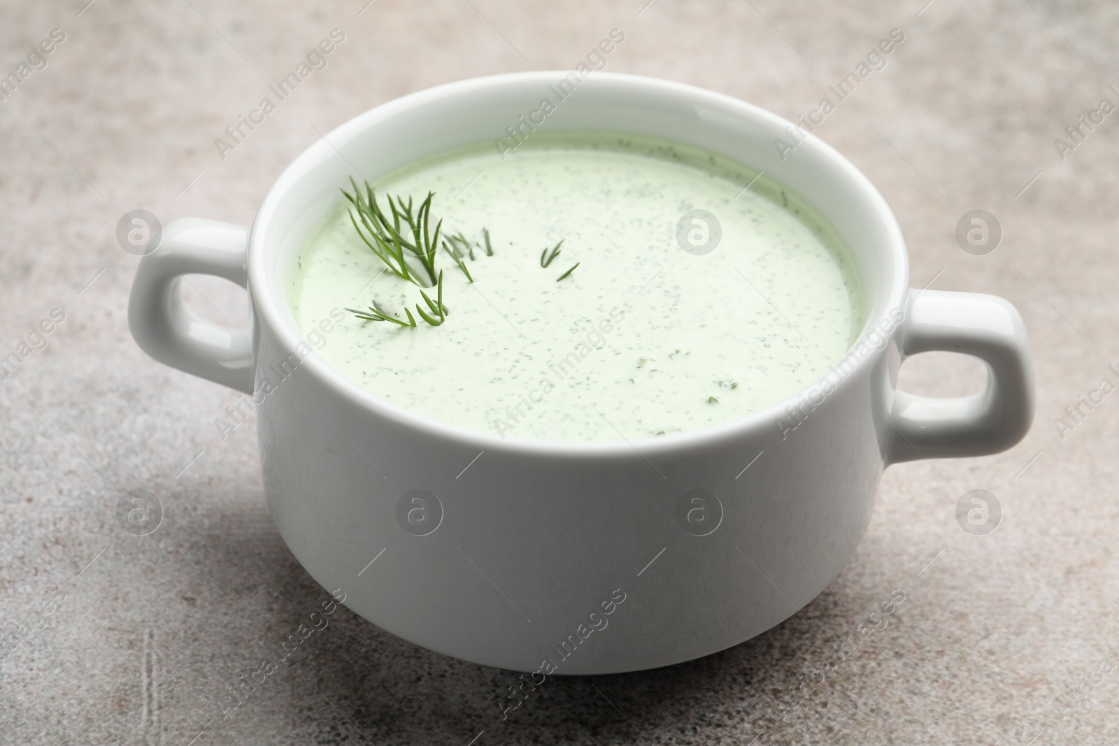 Photo of Tasty cucumber soup with dill on grey table, closeup