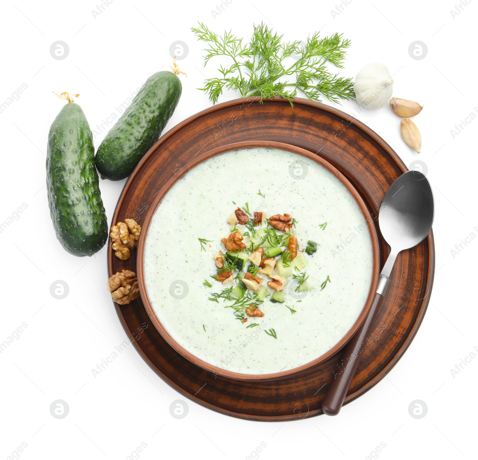 Photo of Tasty cucumber soup with dill, walnuts and ingredients isolated on white, top view