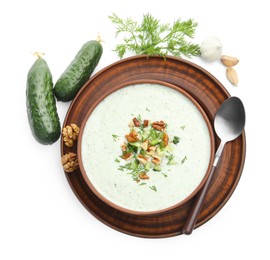 Photo of Tasty cucumber soup with dill, walnuts and ingredients isolated on white, top view