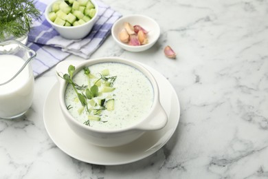 Photo of Tasty cucumber soup with dill, microgreens and ingredients on white marble table, closeup