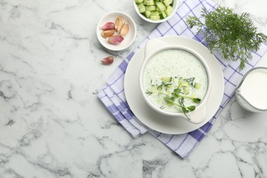 Photo of Tasty cucumber soup with dill, microgreens and ingredients on white marble table, flat lay. Space for text