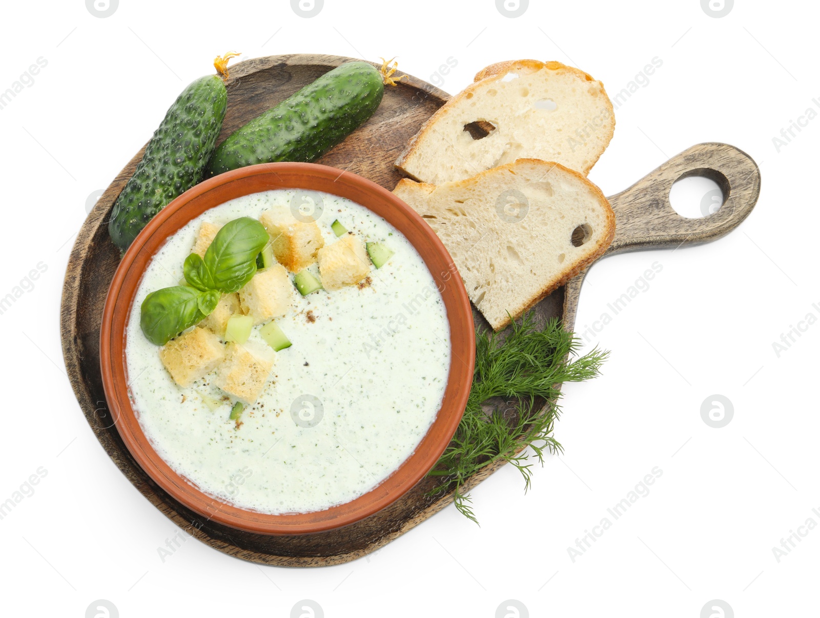 Photo of Tasty cucumber soup with croutons, basil, bread and ingredients isolated on white, top view
