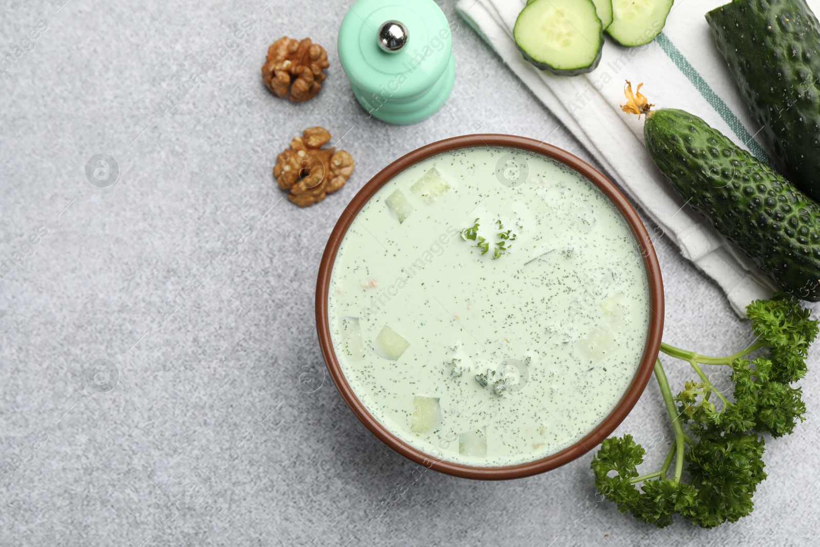 Tasty cucumber soup and ingredients on light grey table, flat lay. Space for text Photo of Tasty cucumber soup and ingredients on light grey table, flat lay. Space for text