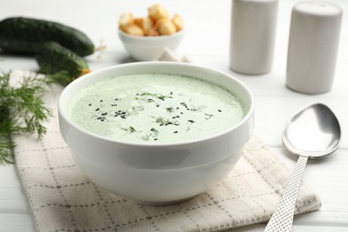 Photo of Tasty cucumber soup served on white table, closeup