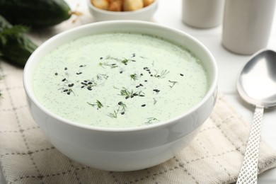 Photo of Tasty cucumber soup served on white table, closeup