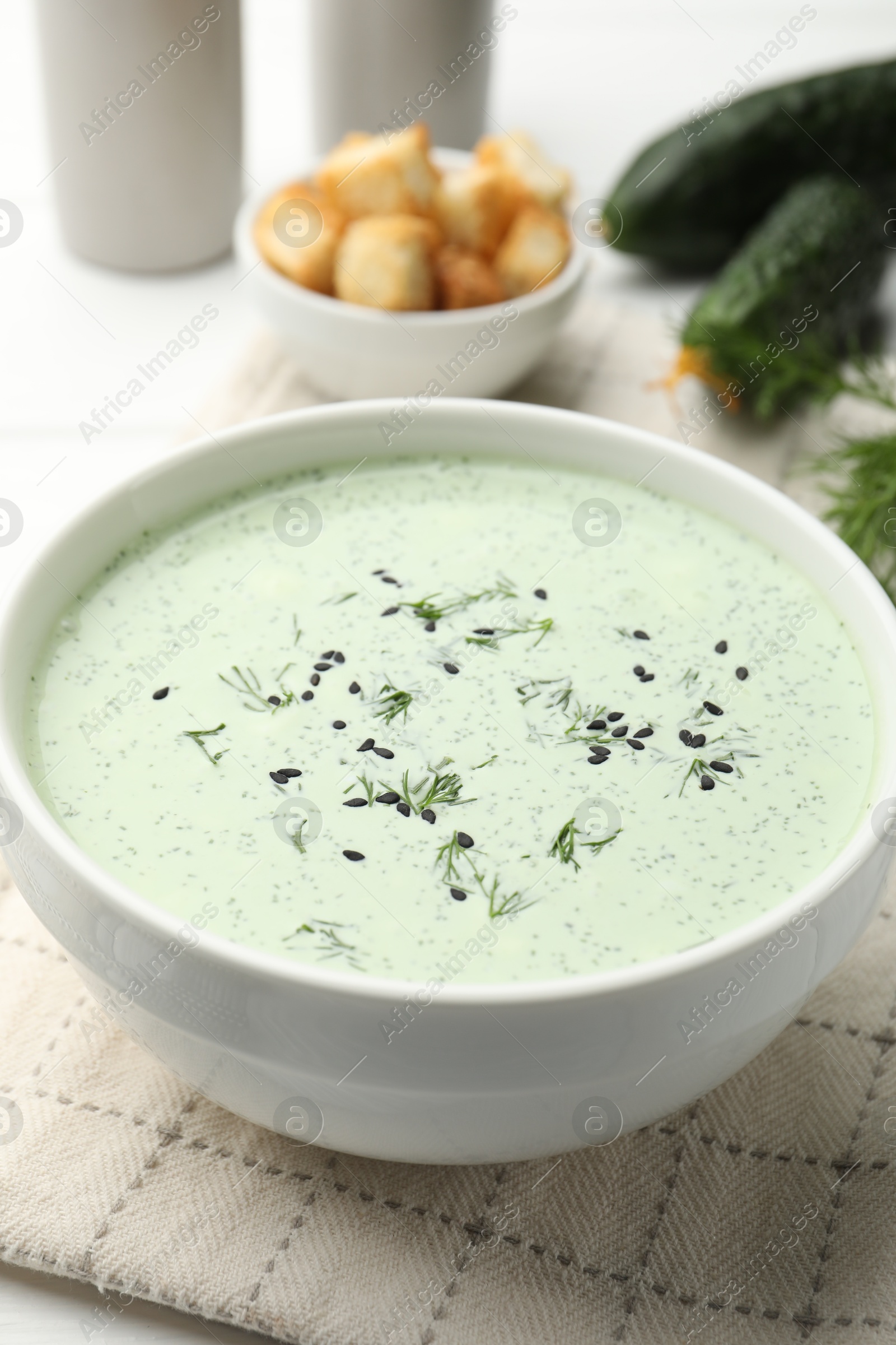 Tasty cucumber soup, croutons and ingredients on white wooden table, closeup Photo of Tasty cucumber soup, croutons and ingredients on white wooden table, closeup