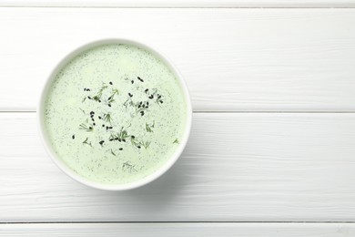 Photo of Tasty cucumber soup with dill and sesame seeds on white wooden table, top view. Space for text