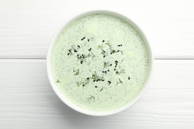 Photo of Tasty cucumber soup with dill and sesame seeds on white wooden table, top view
