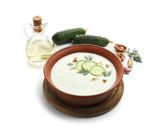 Photo of Tasty cucumber soup with dill, walnuts and ingredients isolated on white
