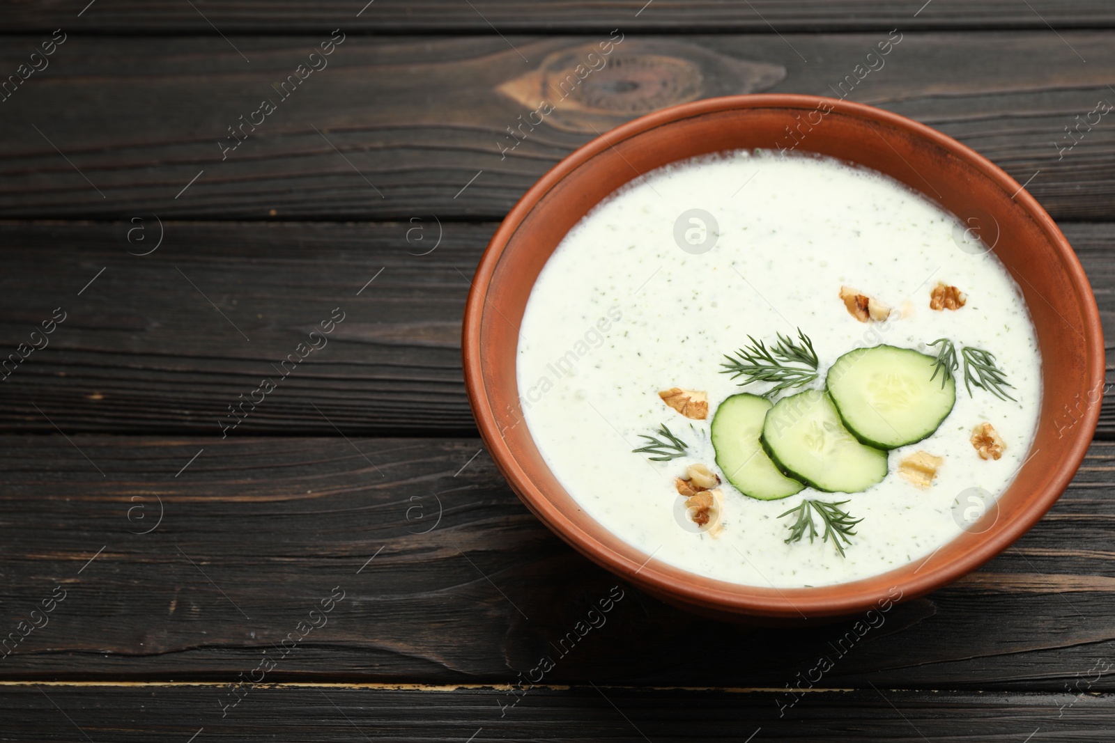 Tasty cucumber soup with dill and walnuts on wooden table, closeup. Space for text Photo of Tasty cucumber soup with dill and walnuts on wooden table, closeup. Space for text