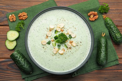 Photo of Tasty cucumber soup with croutons and broccoli on wooden table, flat lay