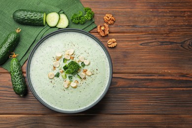 Photo of Tasty cucumber soup with croutons and broccoli on wooden table, flat lay. Space for text
