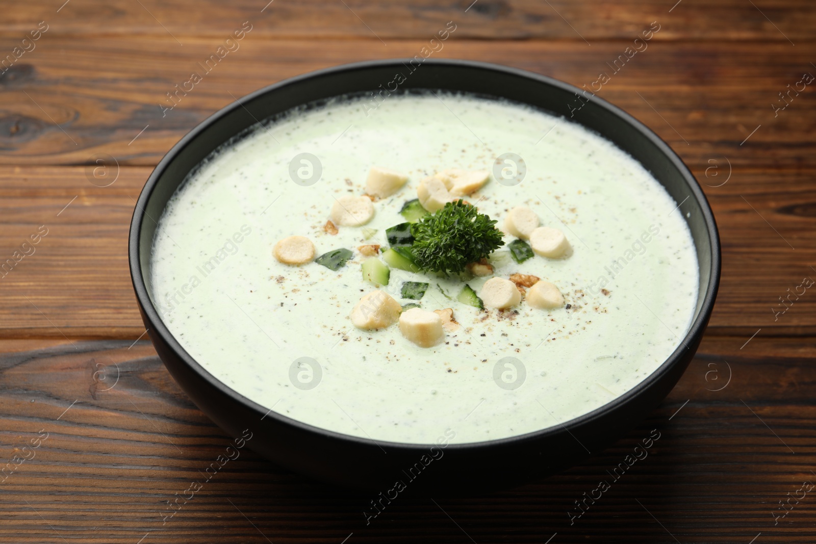 Tasty cucumber soup with croutons and broccoli on wooden table, closeup Photo of Tasty cucumber soup with croutons and broccoli on wooden table, closeup