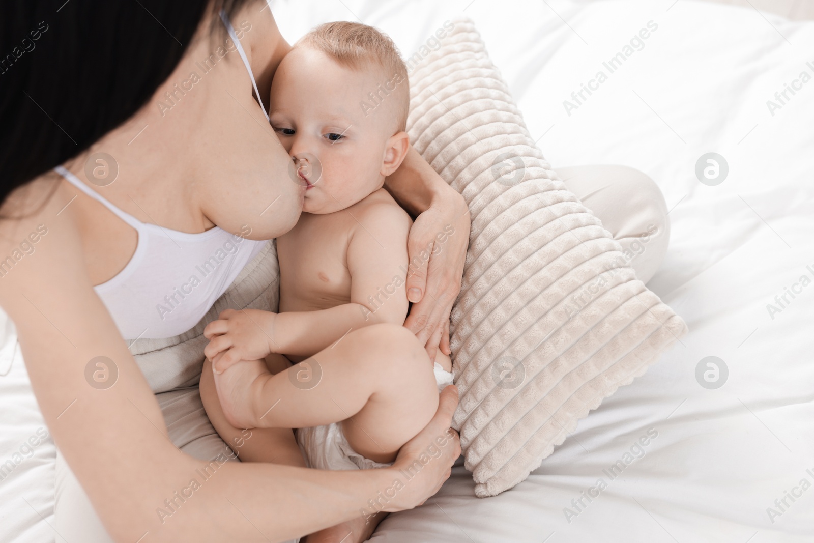 Mother breastfeeding her little baby on bed, above view Photo of Mother breastfeeding her little baby on bed, above view