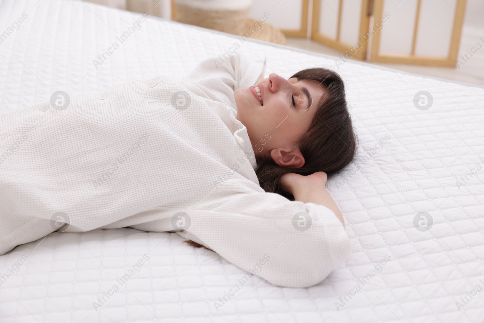Beautiful woman lying on soft mattress at home Photo of Beautiful woman lying on soft mattress at home
