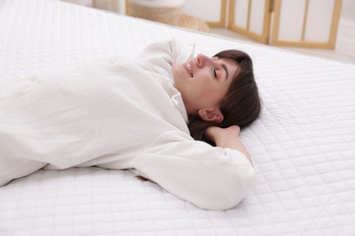 Photo of Beautiful woman lying on soft mattress at home