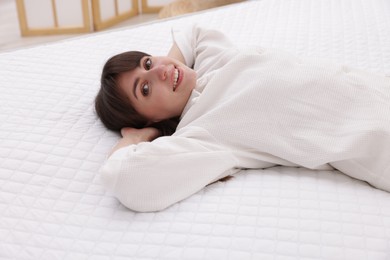 Photo of Beautiful woman lying on soft mattress at home