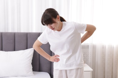 Photo of Woman suffering from back pain at home