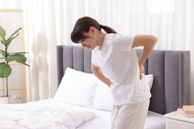 Photo of Woman suffering from back pain at home