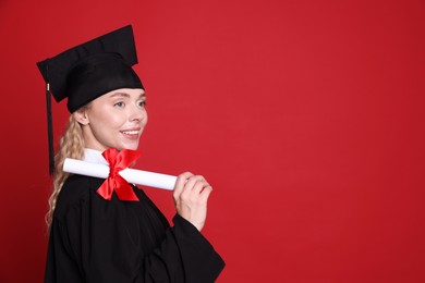Photo of Happy student with diploma after graduation on red background. Space for text