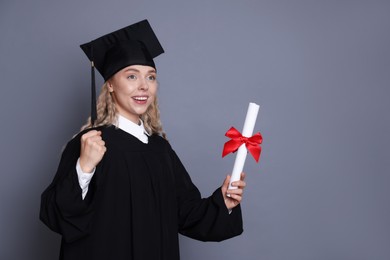 Photo of Happy student with diploma after graduation on grey background