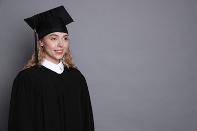 Photo of Happy student after graduation on grey background. Space for text