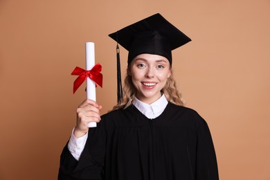 Photo of Happy student with diploma after graduation on beige background