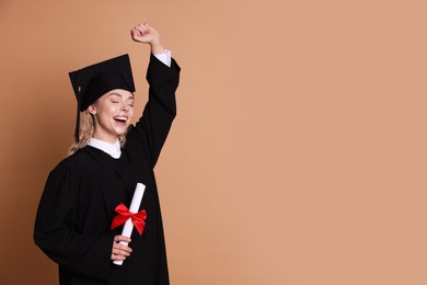 Photo of Happy student with diploma after graduation on beige background. Space for text
