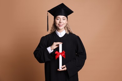 Photo of Happy student with diploma after graduation on beige background