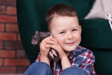 Photo of Little boy with his pet rat at home