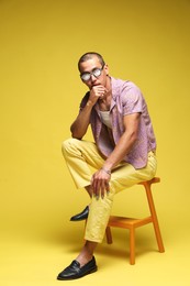 Photo of Fashionable portrait of handsome man in stylish outfit on color background