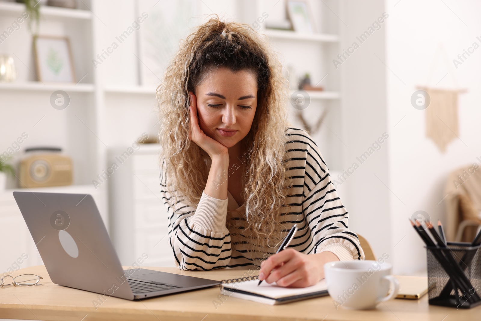 Woman working at desk in home office Photo of Woman working at desk in home office