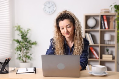 Photo of Woman working with laptop at desk in home office