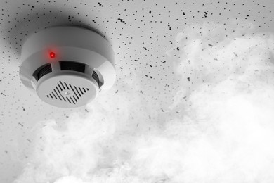 Image of Fire alarm system. Detector on ceiling triggered by smoke