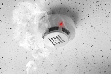 Image of Fire alarm system. Detector on ceiling triggered by smoke