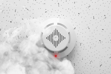 Image of Fire alarm system. Detector on ceiling triggered by smoke, bottom view