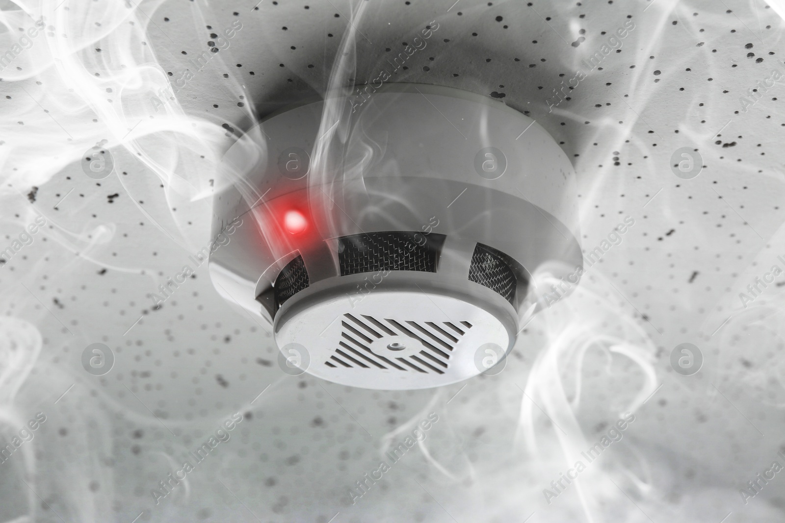 Fire alarm system detector on ceiling triggered by smoke Image of Fire alarm system detector on ceiling triggered by smoke