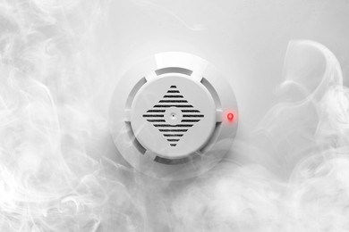 Image of Fire alarm system detector on ceiling triggered by smoke, bottom view