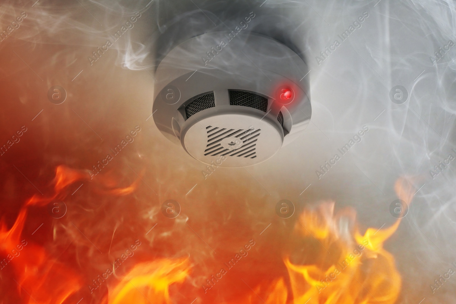 Fire alarm system detector on ceiling triggered by smoke and flame Image of Fire alarm system detector on ceiling triggered by smoke and flame
