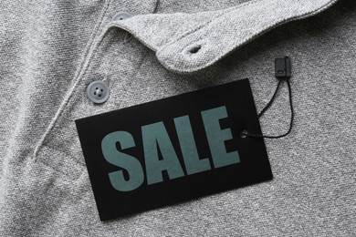 Image of Black Sale tag on grey shirt, top view