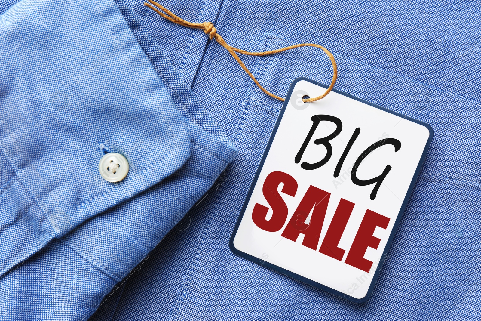 Sale tag on blue denim shirt, top view Image of Sale tag on blue denim shirt, top view