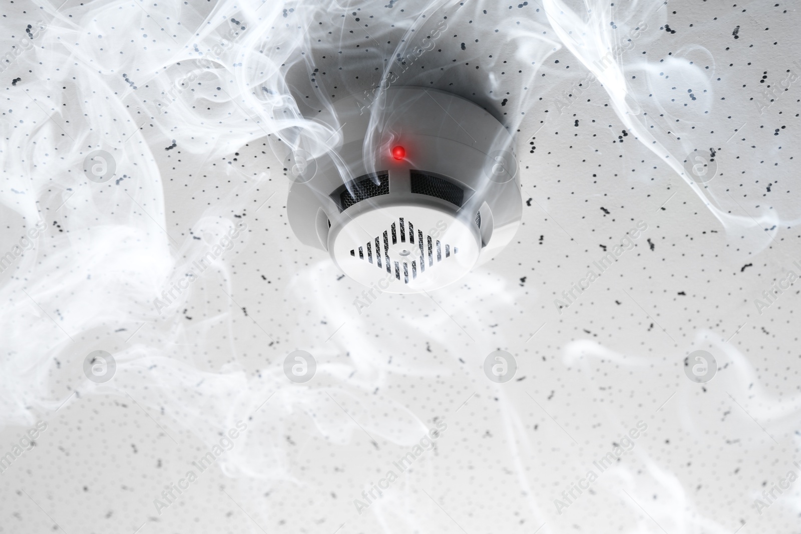 Fire alarm system. Detector on ceiling triggered by smoke Image of Fire alarm system. Detector on ceiling triggered by smoke