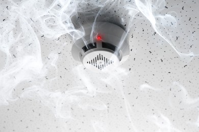Image of Fire alarm system. Detector on ceiling triggered by smoke