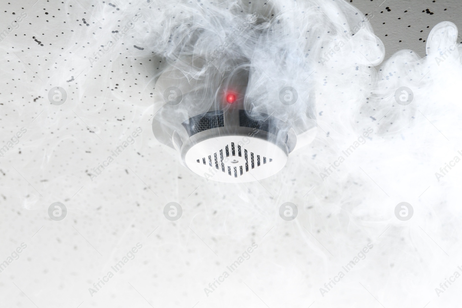 Fire alarm system. Detector on ceiling triggered by smoke Image of Fire alarm system. Detector on ceiling triggered by smoke